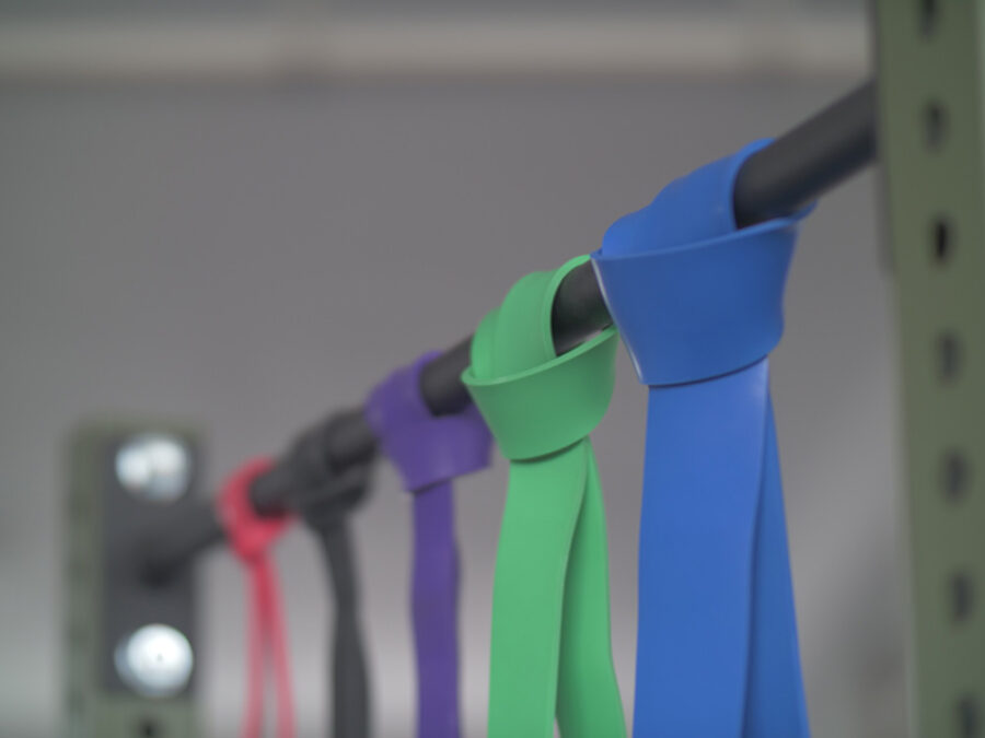 Various exercise bands draped over a pull-up bar